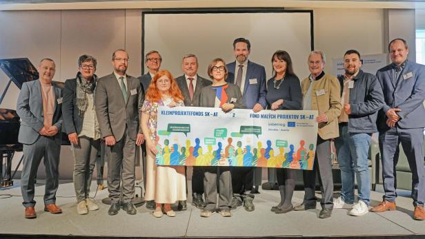 Vertreterinnen und Vertreter aus Österreich und der Slowakei präsentieren bei der Eröffnungsveranstaltung in Hainburg an der Donau das Banner des Kleinprojektefonds SK-AT.