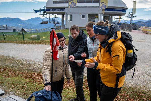 Vier Personen rätseln gemeinsam beim Mountain Escape Trail auf der Gemeindealpe Mitterbach.