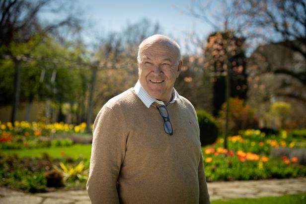 Anton Starkl Senior steht lächelnd im blühenden Garten der Gärtnerei Starkl.