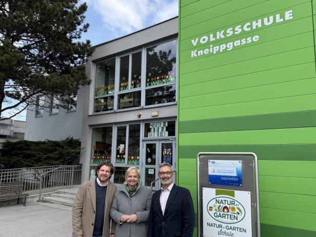 Drei Personen vor einem Gebäude