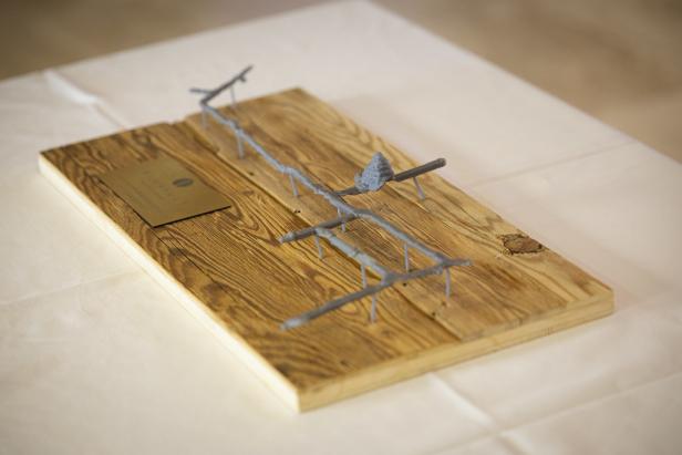 Modell einer Stollenanlage auf einer Holzplatte mit Metallstruktur und Infotafel.