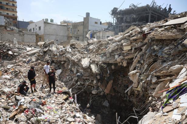 People gather at the site of an Israeli strike carried out before a 10-day ceasefire between Lebanon and Israel went into effect, in Tyre