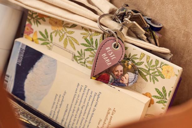 Herzförmiger Schlüsselanhänger mit Foto und Aufschrift „Beste Mama“ an einem Schlüsselbund.