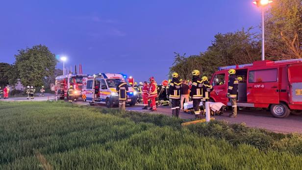 Feuerwehr und Rettungskräfte arbeiten an einer Unfallstelle mit mehreren Einsatzfahrzeugen.