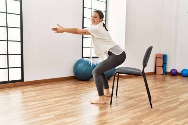 Young hispanic woman smiling confident stretching at sport center.