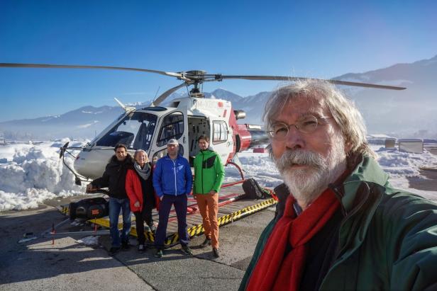 Georg Riha und sein Team nach Drehschluss vor einem Helikopter.