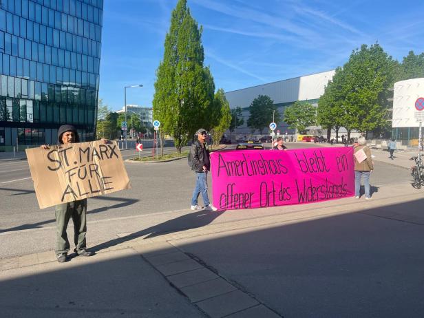 Demonstrierende vor der Messe Wien halten Plakate gegen die geplante Eventhalle in St. Marx und für den Erhalt des Amerlinghauses hoch.