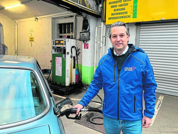 Ein Mann in blauer Jacke tankt ein Auto an einer alten Dieseltankstelle in einer Werkstatt.