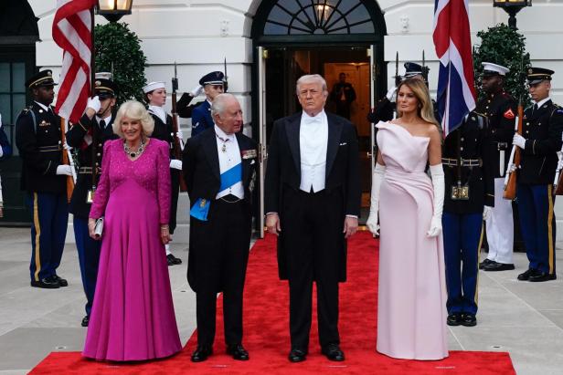 König Charles, Camilla, Donald Trump und Melania stehen auf einem roten Teppich vor dem Weißen Haus.
