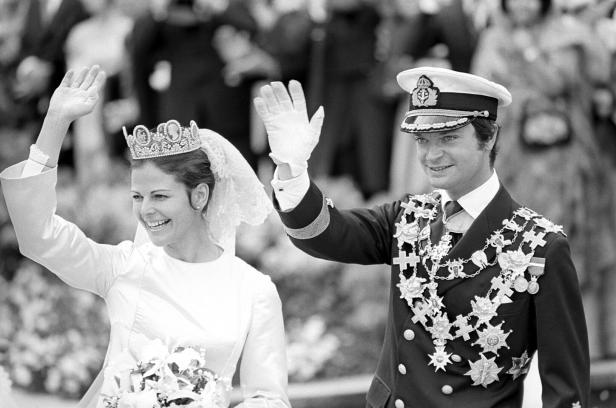 Ein Paar winkt aus einer Kutsche