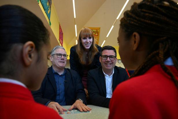 Britain's Prime Minister Keir Starmer, Britain's former Deputy Prime Minister Angela Rayner, and Greater Manchester Mayor Andy Burnham meet with schoolchildren during a visit to a primary school