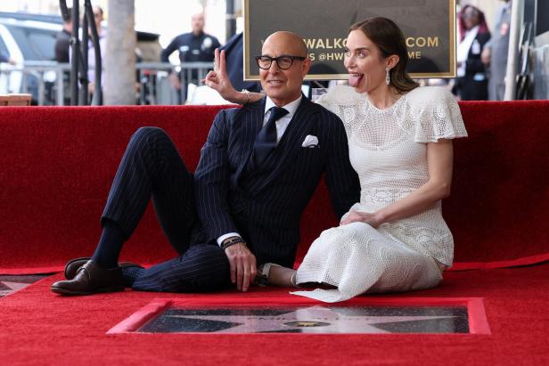 Stanley Tucci und Emily Blunt sitzen auf dem Walk of Fame am Boden vor einem Stern