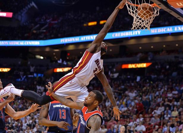 Ein Basketballspieler der Miami Heat beim Dunking über einen Gegenspieler der Washington Wizards.