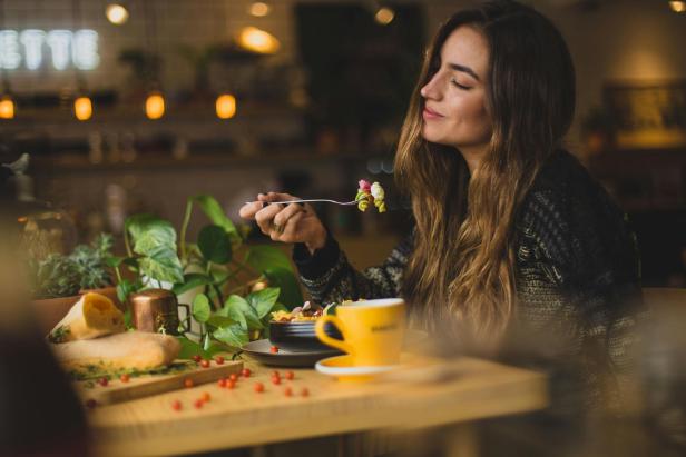 Eine Frau sitzt in einem Restaurant und genießt das Essen. 