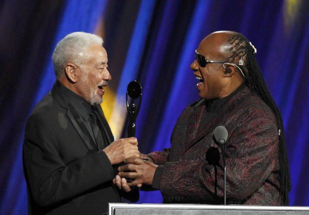 Sam Moore überreicht Stevie Wonder eine Auszeichnung auf einer Bühne.