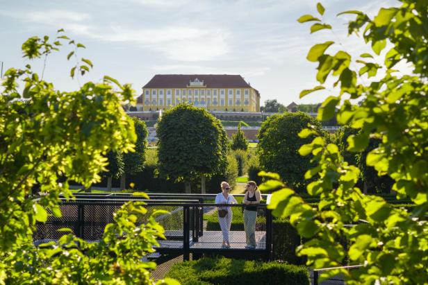 ein barockes Schloss hinter Bäumen versteckt 