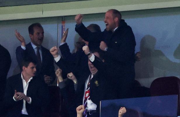 Prinz William jubelt mit erhobenen Fäusten auf einer Tribüne.