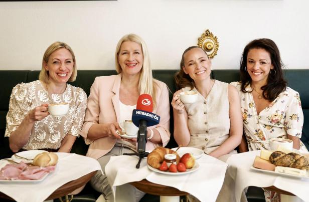 Vier Frauen sitzen lachend an einem Frühstückstisch mit Kaffee, Gebäck und einem Ö3-Mikrofon.