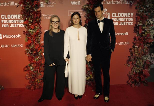 Meryl Streep, Grace Gummer und Mark Ronson posieren vor einem roten Hintergrund für die Clooney Foundation for Justice.