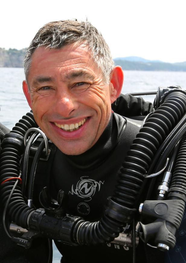 François Sarano, Taucher, Ozeanograf und Autor, in Tauchermontur. 