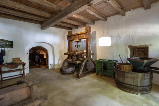 Historische Weinpresse und Geräte zur Traubenverarbeitung im neu eröffneten Presshaus des Museumsdorfs Niedersulz.