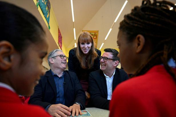 Britain's Prime Minister Keir Starmer, Britain's former Deputy Prime Minister Angela Rayner, and Greater Manchester Mayor Andy Burnham meet with schoolchildren during a visit to a primary school