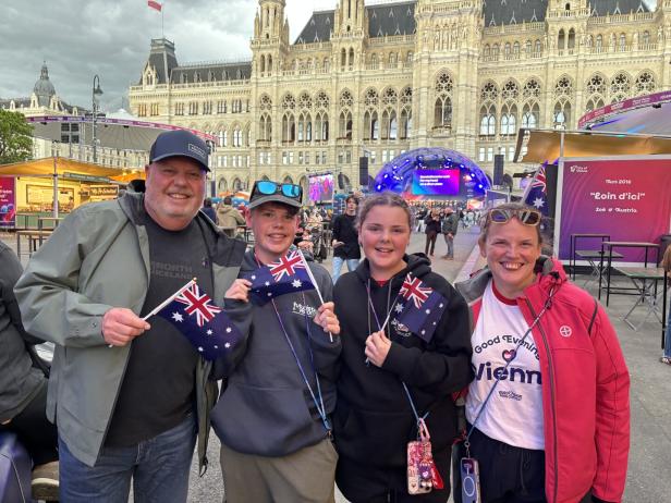 Eine Familie hält australische Flaggen vor dem Wiener Rathaus.