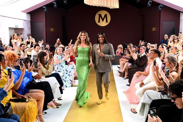 Heidi Klum in einem grünen Kleid läuft gemeinsam mit Stylist Law Roach über den gelben Teppich