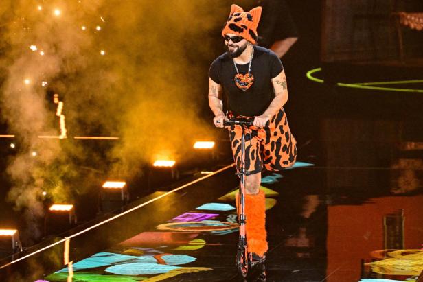 Ein als orange-schwarze Katze verkleideter Akylas fährt während des Eurovision Song Contest Finales in der Wiener Stadthalle auf einem Scooter über die Bühne.