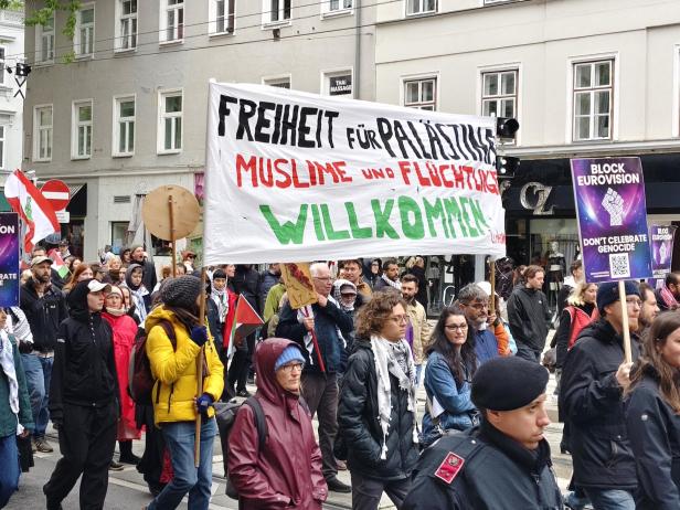 Demonstrierende Menschen mit Transparenten, darunter eines mit der Aufschrift „Freiheit für Palästina, Muslime und Flüchtlinge willkommen“.