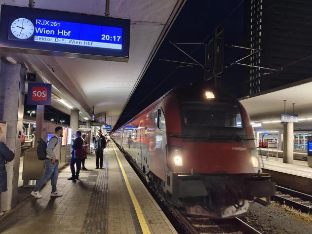 Zug fährt am Bahnsteig in Linz ein. 