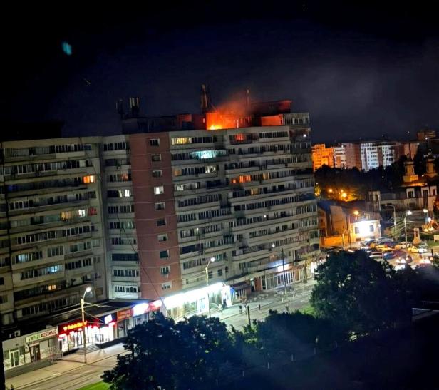 Fire burns on the roof of a 10-story block of flats after a drone crashed into the building in Galati