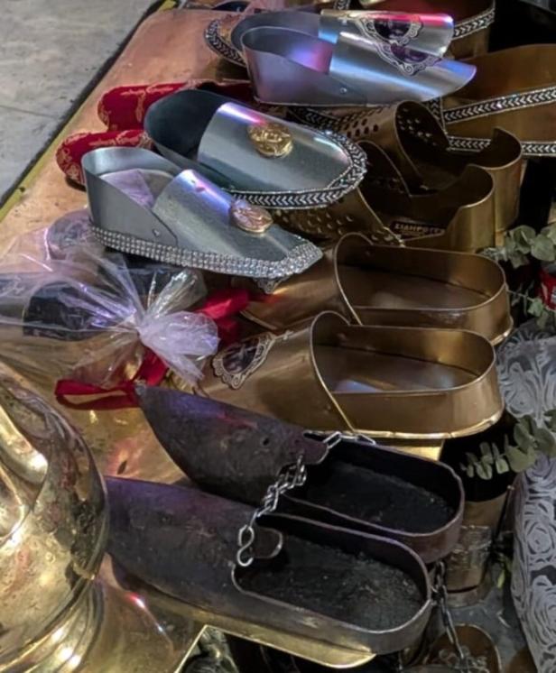 Verschiedene dekorative Schuhe in Gold, Silber und Schwarz sind zu sehen.