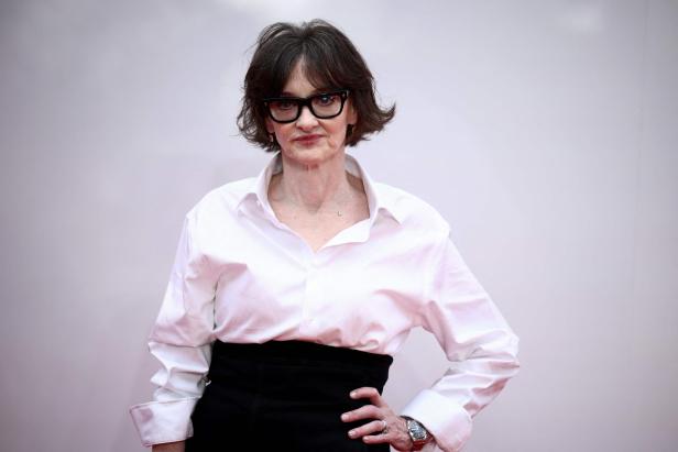 Joan Cusack in einem weißen Hemd und schwarzen Rock.