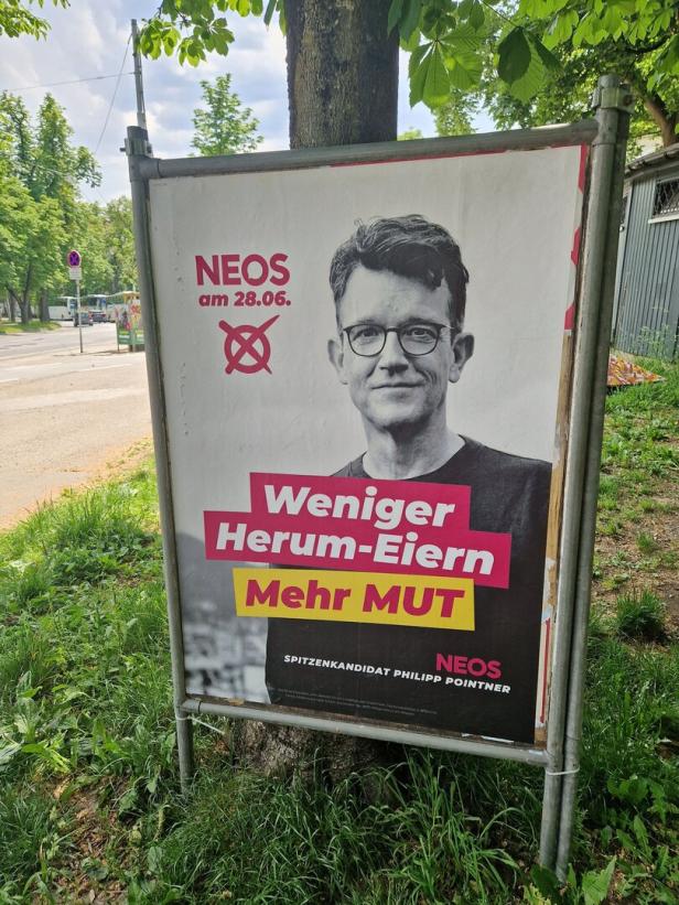 Ein Wahlplakat der Partei NEOS mit dem Slogan „Weniger Herum-Eiern, Mehr MUT“ und dem Bild eines Mannes.