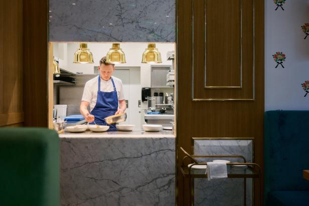 Chefkoch Simon Steindl bereitet Gerichte in der offenen Küche seines Restaurants zu