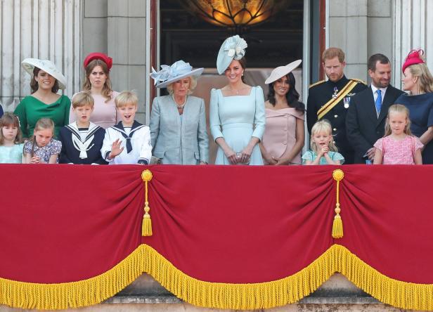 Auf einem Balkon stehen Mitglieder der königlichen Familie, darunter Kate, Meghan und Harry.