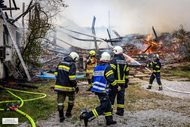 Feuerwehrleute vor einem brennenden Gebäude.