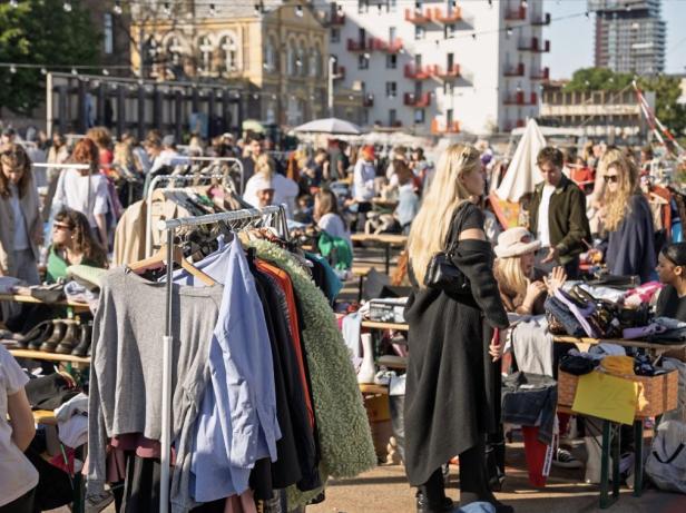 Mehrere Menschen stehen bei einem Flohmarkt.