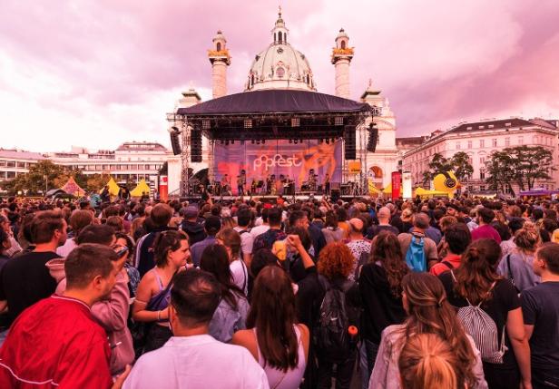 Menschenmenge vor der Popfest-Bühne am Karlsplatz mit der Karlskirche im Hintergrund.
