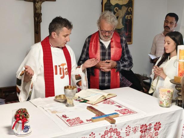 Pfarrer Ignatius und Pater Georg Sporschill am Altar mit einer Ministrantin und einem Messbesucher.