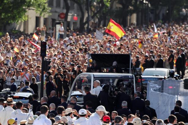 Papst Leo XIV fährt in seinem Papamobil durch eine jubelnde Menschenmenge, in der spanische Flaggen geschwenkt werden.