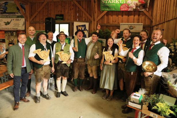 Eine Gruppe in Tracht feiert bei einer Veranstaltung des Breitenfurter Jagdklubs mit Trophäen in einer Holzhalle.