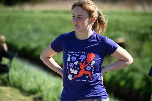 Eine Teilnehmerin des NÖ Frauenlaufs pausiert, sie trägt das diesjährige vom NÖ Frauenlauf gestaltete Sport-Shirt