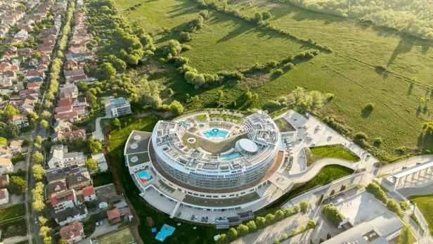 Luftaufnahme eines modernen Hotel- und Spa-Resorts mit Poollandschaft am Stadtrand von Hévíz.