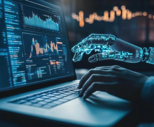 Eine menschliche und eine digitale Hand arbeiten gemeinsam an einem Laptop mit Finanzdaten.