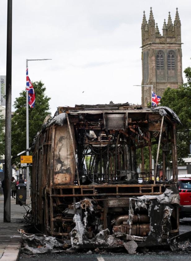 Remains of a burnt bus stand on the Newtownards Road in the aftermath of anti-immigrant protests following a knife attack in Belfast