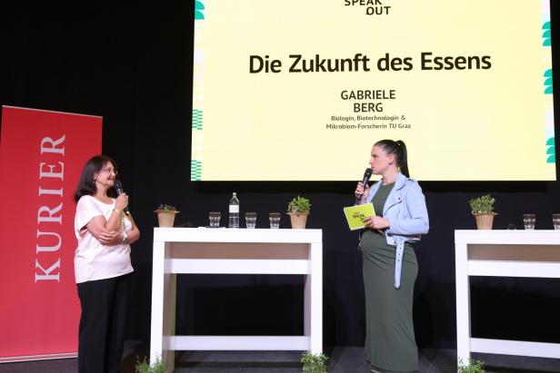 Zwei Frauen sprechen auf einer Bühne mit Mikrofonen, hinter ihnen steht „Die Zukunft des Essens“ auf einer Leinwand.