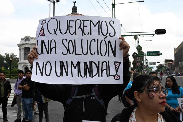 Demonstranten in Mexiko mit einem Schild mit der Aufschrift: "Wir brauchen eine Lösung, keine Weltmeisterschaft"