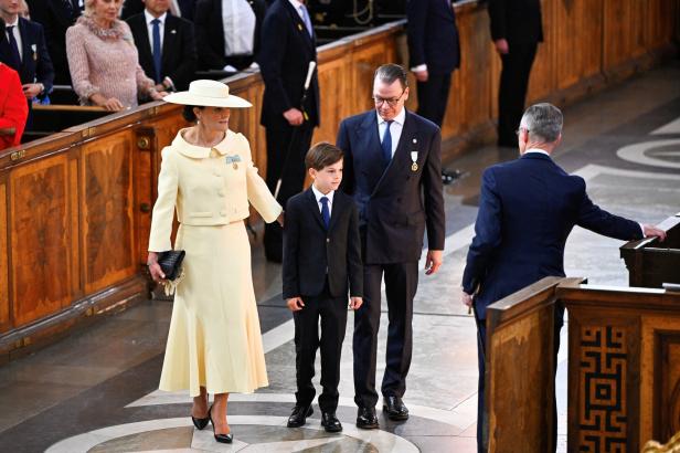Kronprinzessin Victoria von Schweden, Prinz Daniel und Prinz Oscar schreiten in festlicher Kleidung durch eine Kirche.